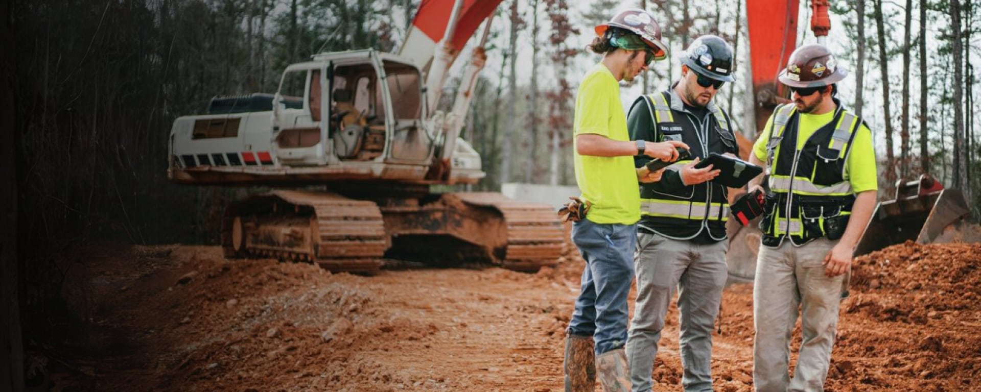  Construction workers on a jobsite with a tablet reviewing plans on Fieldwire