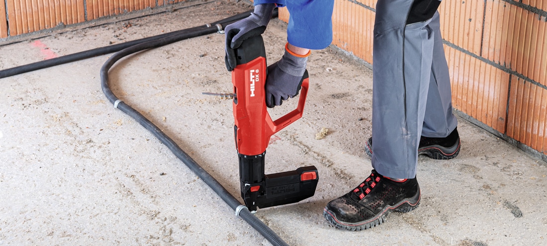 Worker using the DX 6 to fasten to concrete