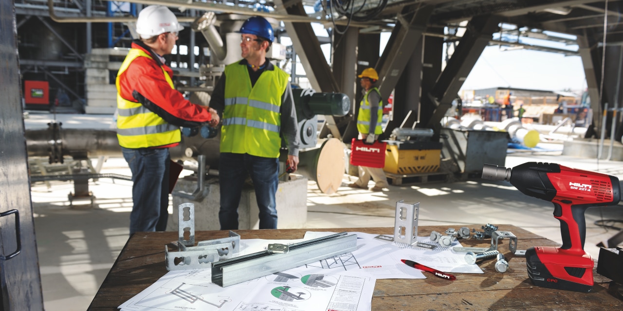 Hilti engineer onsite with a customer with shop drawings in the foreground