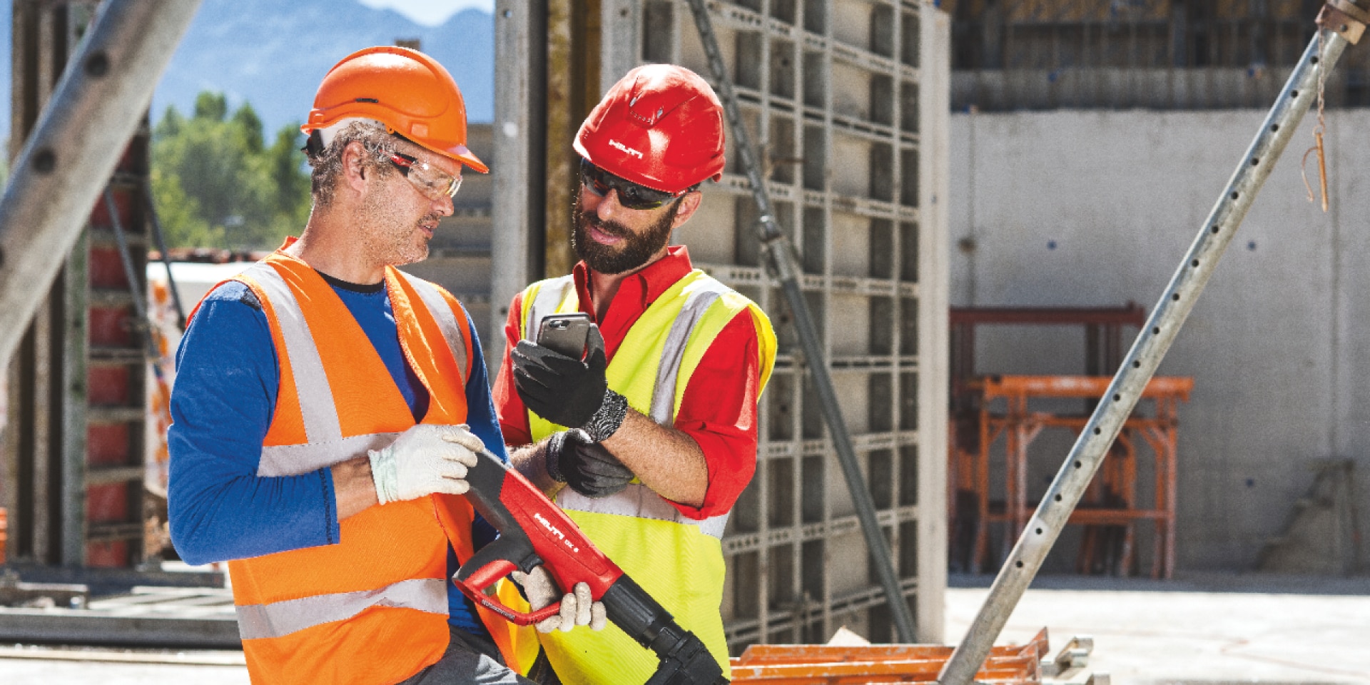 two construction workers looking at a phone