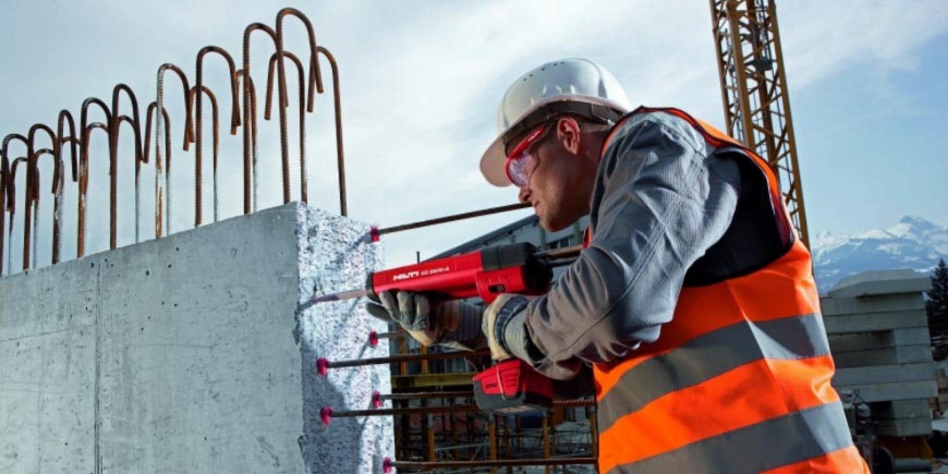 Construction worker reinforcing rebar vertically on a concrete wall